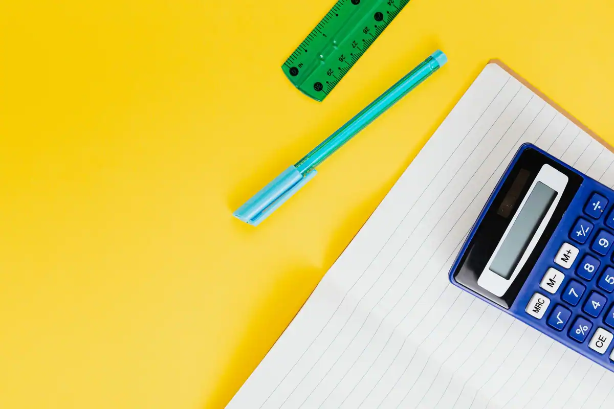 Caiet, pix și calculator pe un fundal galben, pentru socoteala cheltuielilor