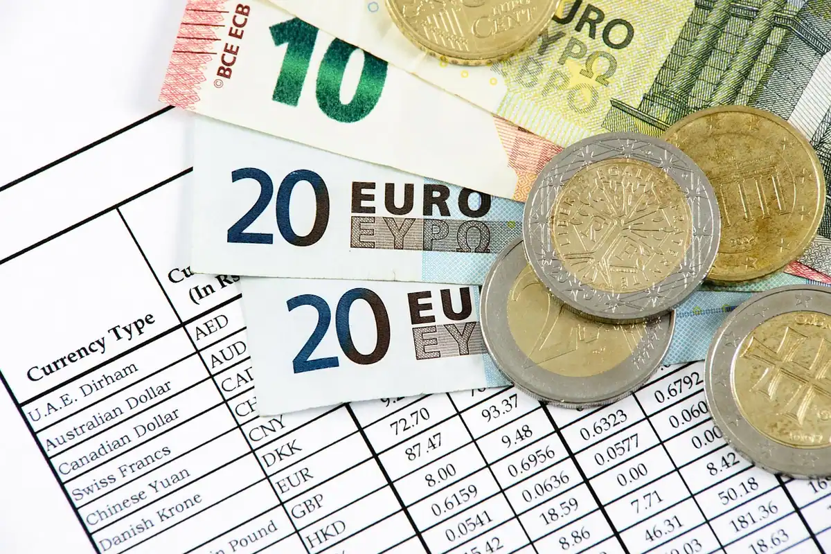 Birou cu bani, documente bancare și calculator, folosite la compararea formelor de plată pentru o mașină