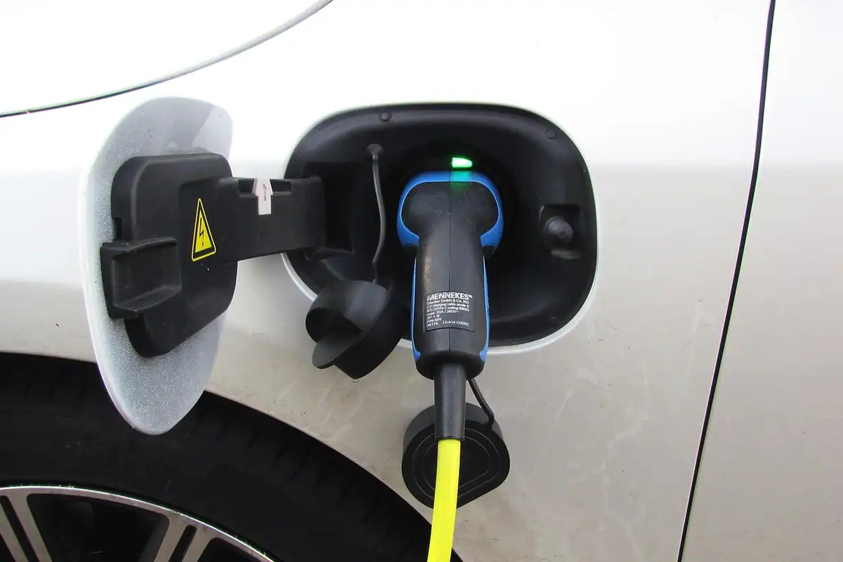 Cablu de încărcare conectat la o mașină hibridă plug-in, parcată într-un garaj