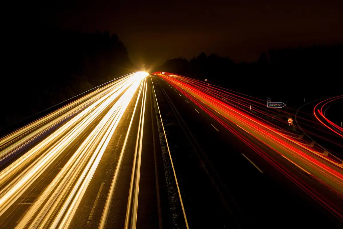 Autostradă noaptea, cu urme luminoase de faruri, pentru drumuri lungi unde se alege încărcarea rapidă DC