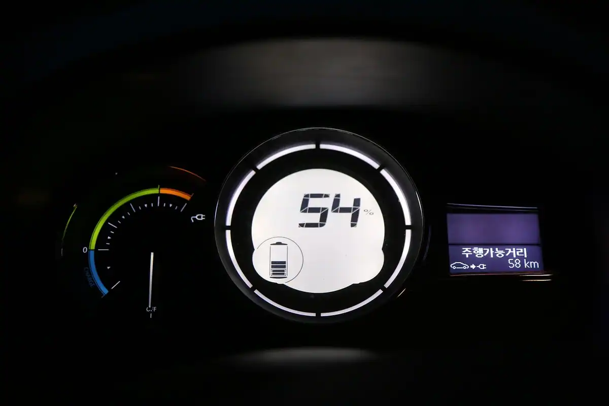 Bord de mașină electrică cu afișaj de energie, pe care se citesc consumul în kilowați și autonomia