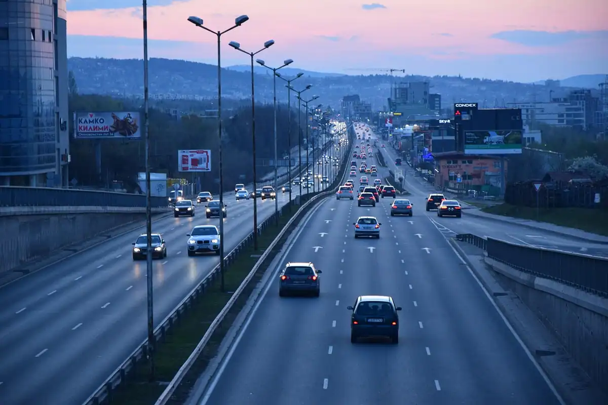 Autostradă cu trafic la amurg, cu mașinile cu farurile aprinse