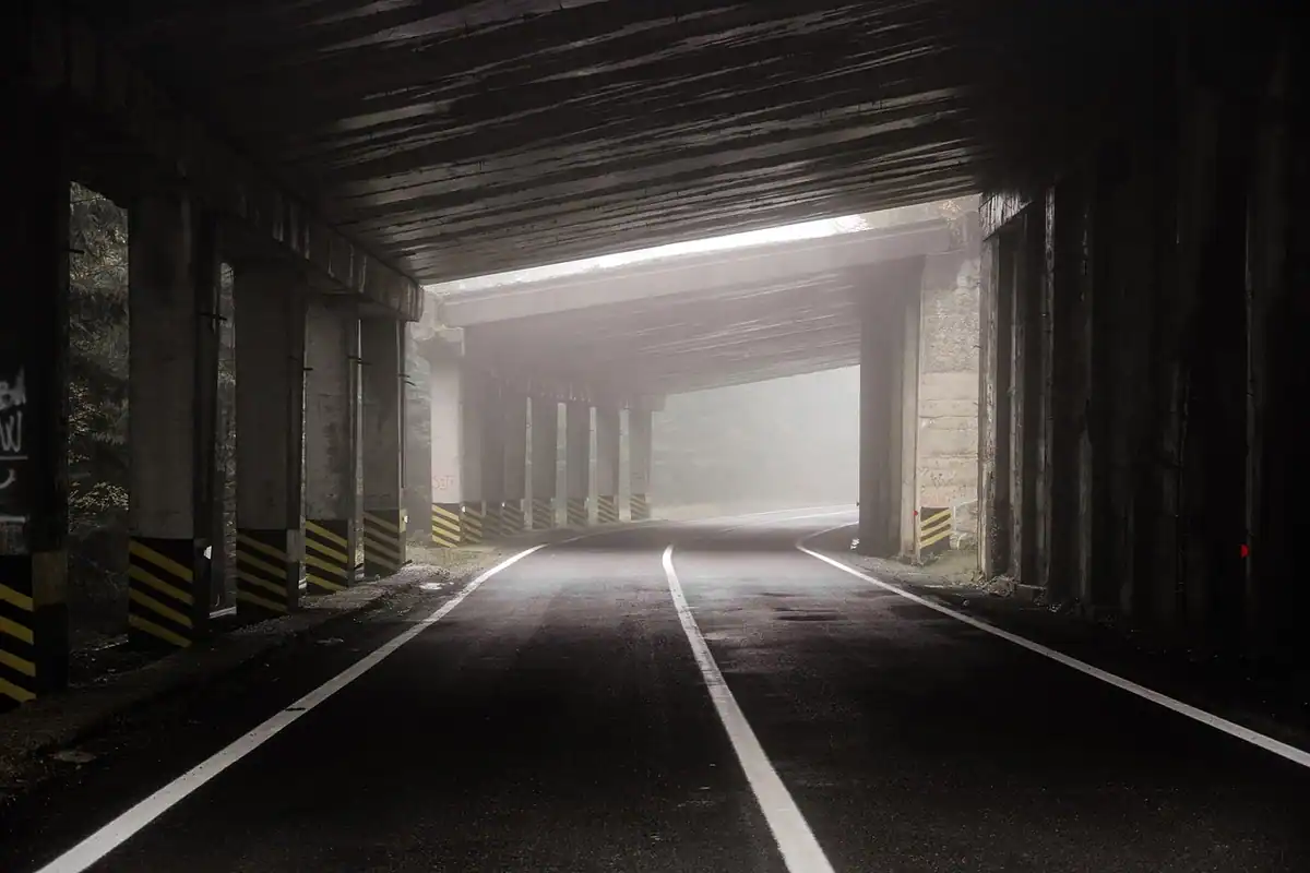 Tunel întunecat cu un drum care duce spre lumina din capăt