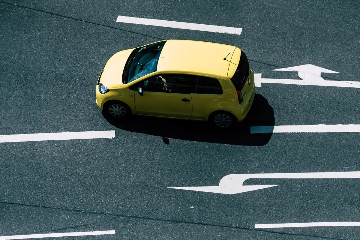 Mașină mică galbenă parcată pe o stradă liniștită, potrivită ca primă mașină pentru un șofer începător