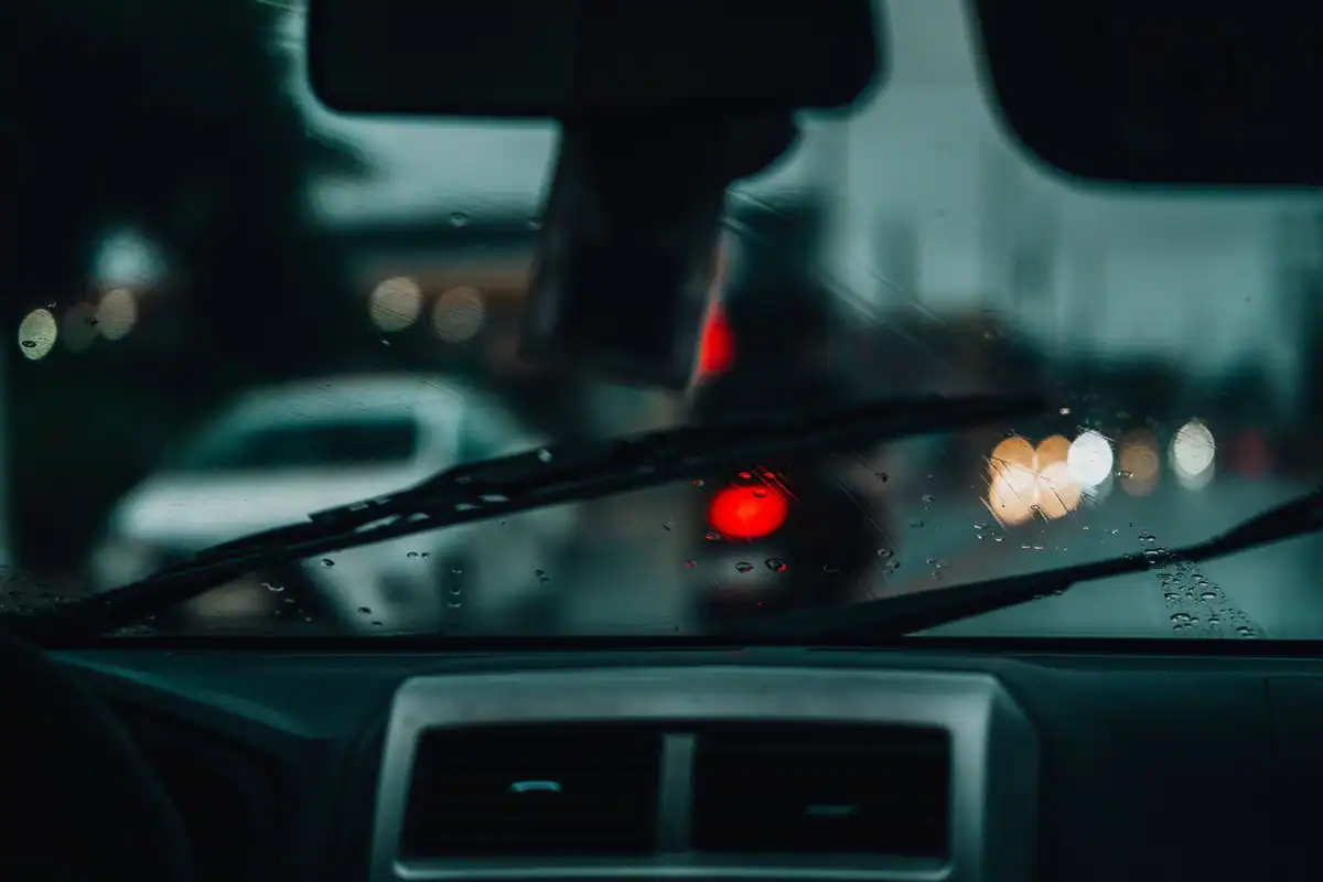 Parbriz cu picături de ploaie și stopurile mașinilor din față