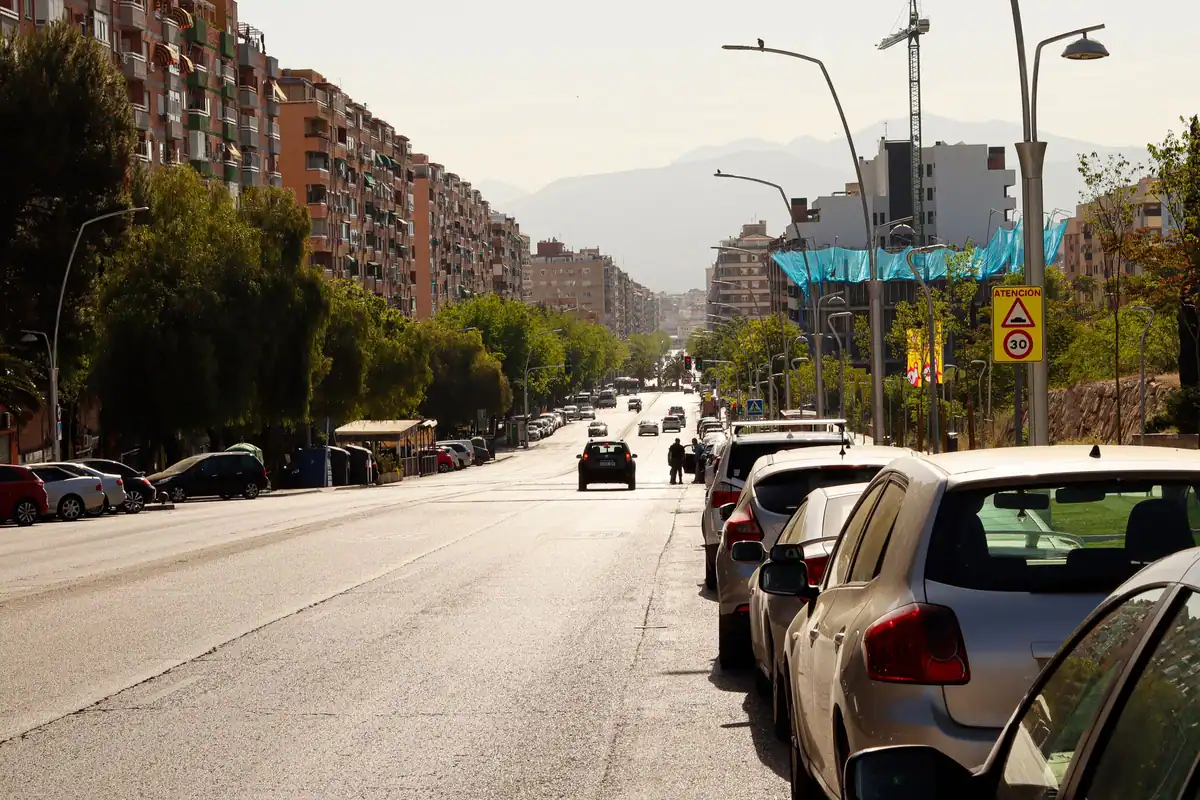 Stradă cu mașini parcate pe margine și clădiri în fundal