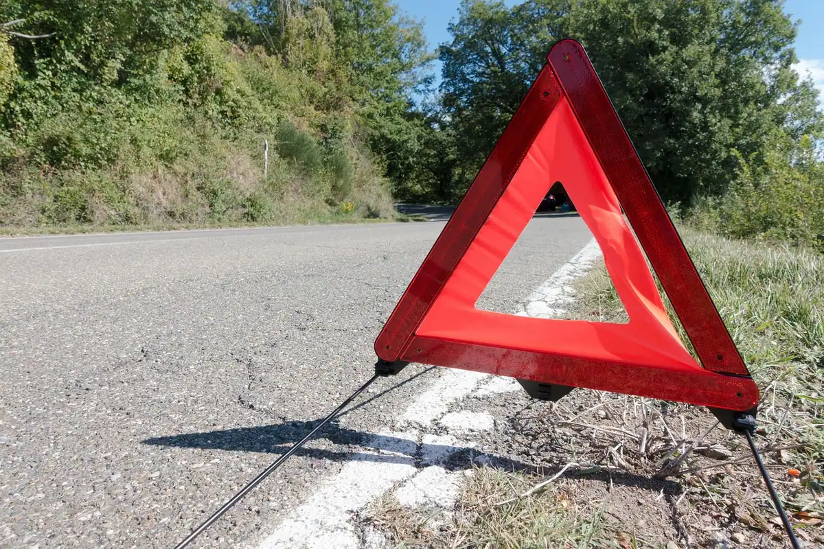 Triunghi reflectorizant roșu de avertizare, așezat pe șosea
